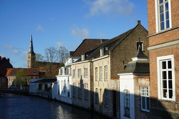 Blick von der Molenbrug in der Langestraat auf Gracht und Kanal mit Kirchturm der Sint Anna Kirche als Teil des Unesco Weltkulturerbe in den Gassen der Altstadt von Brügge in Westflandern in Belgien