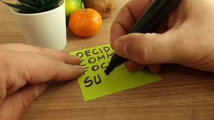 Man handwriting motivational and inspirational quote - decide, commit, focus, succeed on sticky note. Motivation and inspiration concept