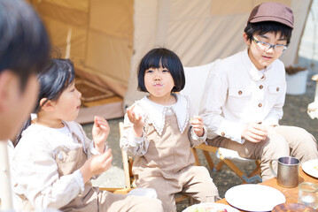 Obraz na płótnie Canvas キャンプで食事を楽しむ子供たちと親