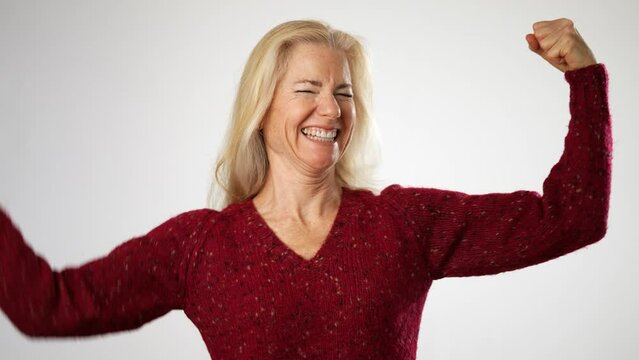 Strong sporty elderly gray-haired blonde woman lady 50s 60s years old show biceps muscles on hand demonstrate strength power isolated on solid white background studio portrait