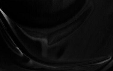 Black gray satin dark fabric texture luxurious shiny that is abstract silk cloth background with patterns soft waves blur beautiful.