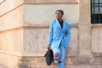 Fototapeta na wymiar Black businesswoman poses on the street with a blue suit