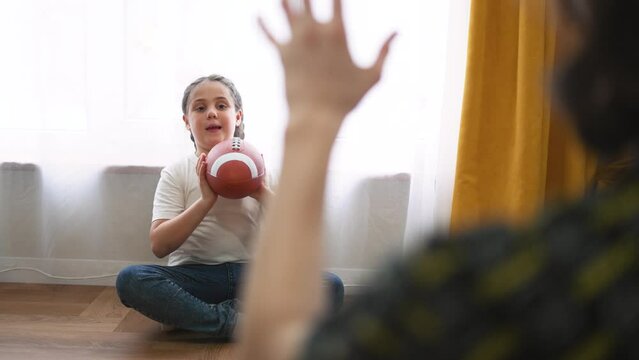 Happy family.Child with his father plays with ball at home.Fun home game. Education in kindergarten.Children dream in game.Family happiness at home. Rugby ball. American football at home. Kindergarten