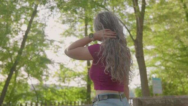 Young woman with gray hair looking around the forest