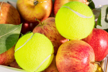 Tennis composition with close up yellow tennis balls with natural red apples. Tennis competition....