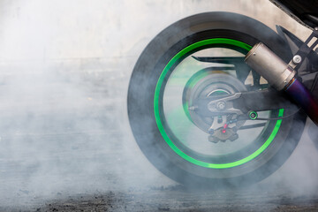 Motorbike burning tire rubber on road, Motorbike wheel drifting and white smoking on track, Motorcycle wheel on racing track with white smoke. - obrazy, fototapety, plakaty