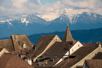 Fototapeta na wymiar The roofs of the old town of Rapperswil with the snow-capped alps in the background, Rapperswil-Jona, St. Gallen, Switzerland