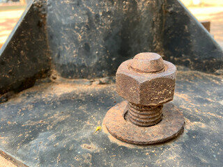 Close-up of old iron bolt on the black steel plate with copy space.   