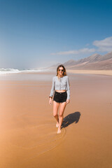 happy young woman on the wild beach of cofete during her summer trip on the canary island of fuerteventura
