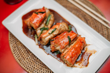 A ready-made dish of fresh red Kamchatka crab legs on the table in the restaurant hall.  Cooked crab meat in a shell on a plate