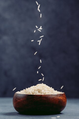 Grains of white rice falling into bowl