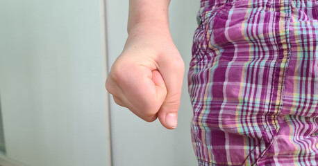 Child strongly clenches fist and emotions of perseverance