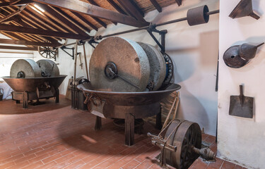 Olive oil press is installed in premises of ancient equipment for production of olive oil, stone...