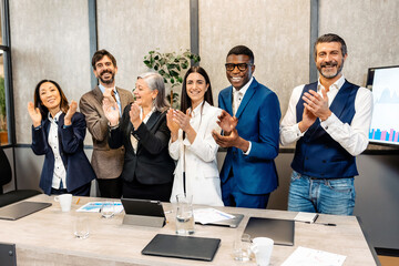 Multiracial businesspeople clapping hands in office