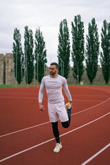 Obraz premium Man Warming Up and Stretching Before Workout and Running