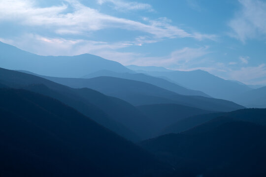 Blue gradient layers in nature with sky and mountains. Light and dark tones of blue color, abstract background.