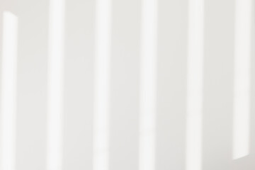 Light and shadows lines from curtain and silates on the white wall. Sunny day, the sun's rays. Mockup, copy space for text	