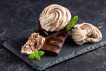 Meringues with dark chocolate close up.