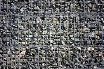 rubble stones under the grid, a wall of rubble mesh holding stones