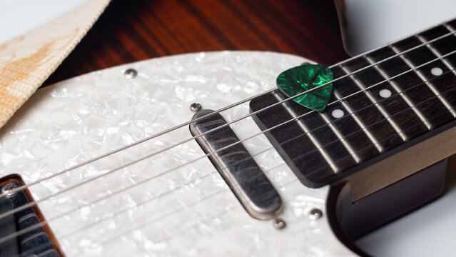 Green Guitar Pick in Strings of Electric Guitar