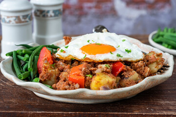 Corned beef hash with fried egg and green beans