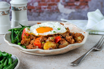 Corned beef hash with fried egg and green beans