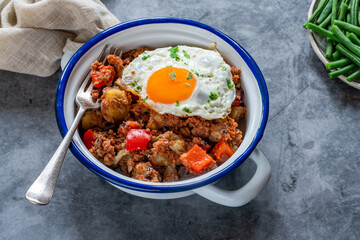 Corned beef hash with fried egg and green beans