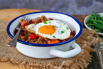 Corned beef hash with fried egg and green beans