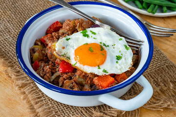 Corned beef hash with fried egg and green beans