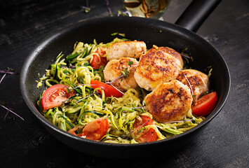 Zucchini spaghetti pasta  with chicken meatballs in pan.