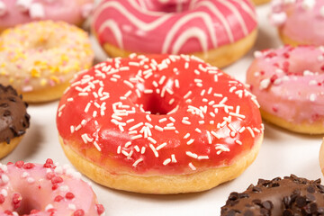 Donuts with red and pink glaze, top view. Lots of donuts, sweet and delicious food