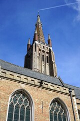 Der Kirchturm der Liebfrauenkirche im Stil der Gotik mit alten Häusern mit Spitzgiebel im...