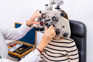 Optician and optometrist. Eye doctor using phoropter.