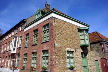 Restaurierte Fassaden aus Backstein mit schönen Fenstern und Türen vor blauem Himme als Teil des...