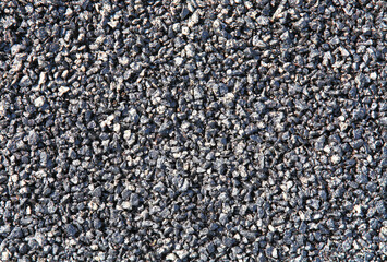 New asphalt surface, background. Detailed texture of fresh bitumen. Black stone backdrop. Road foundation, based on crushed stone and resin close-up. Highway repair and construction