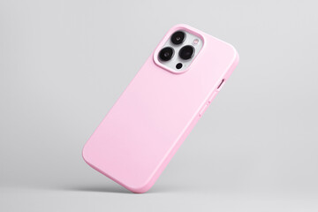 iPhone 13 Pro in pink soft silicone case falls down back view, phone case mockup isolated on grey...