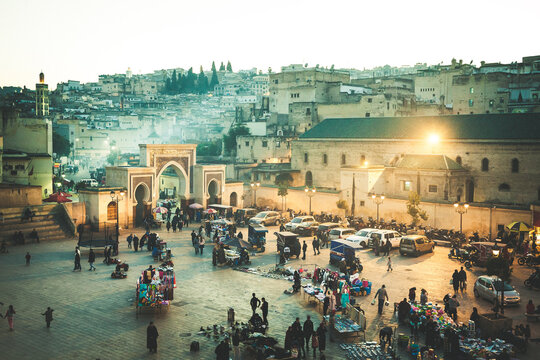 Arabic square Rcif in Fes in Morocco at sunset. People in market and street food.  Ancient medina
