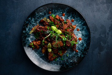 Dinner fried chicken fillet with zucchini, tomatoes, beans, sweet pepper in sweet and sour sauce and microgreens.