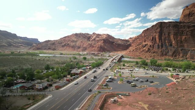 Aerial panning above parking lots and bike path along Colorado River in Moab Utah in spring time
