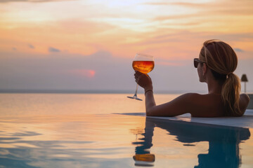 Woman watching the sunset with a cocktail in an infinity pool, showcasing luxury lifestyle, vacation, resort, wealth, and opulence, generative ai