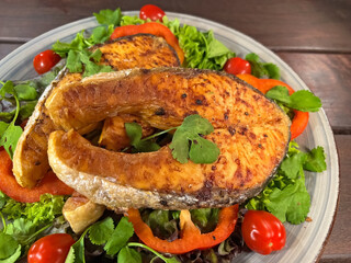 Salmon steak with vegetables in a plate