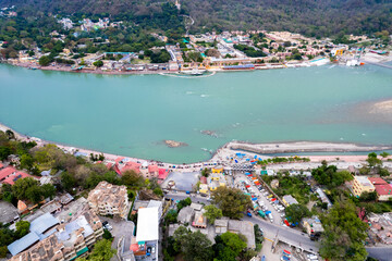 aerial drone shot over ram setu jhula suspension bridge with temples on the bank of river ganga in...