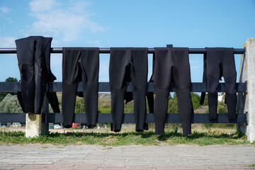 Diving and surfing rubber suit drying hanging on the beach. vacation in Summertime