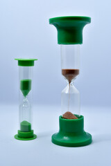 Glass hourglass on a white background. Multicolored glass hourglass.