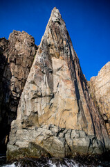 Large triangular sea cliff with blue sky
