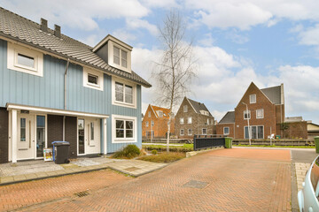 a street with houses in the background and a car parked on the side of the road next to the house