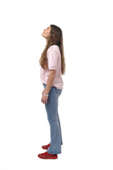 side view of a young girl standing and looking up on white background