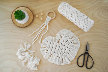 Fototapeta na wymiar Macrame handmade napkin in the form of heart. Eco diy home decoration. Natural materials, cotton thread. St. Valentine's Day.