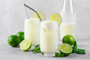 Brazilian Lemonade, Refreshing Creamy Lemonade or Limeade with Lime Slices and Mint on Grey Background