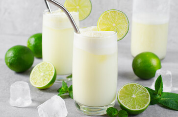 Brazilian Lemonade, Refreshing Creamy Lemonade or Limeade with Lime Slices and Mint on Grey Background